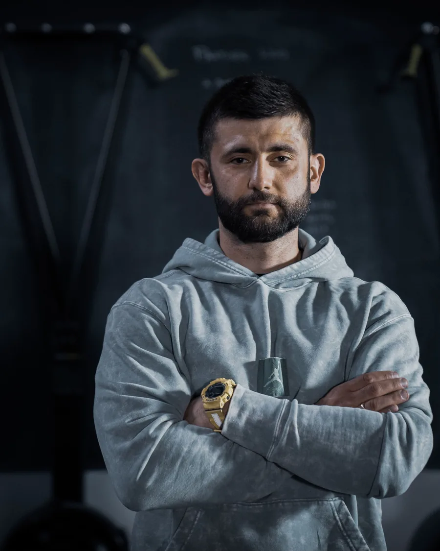Artur Aleksiewicz — trener personalny z Wrocławia, na siłowni ze skrzyżowanymi rękami
